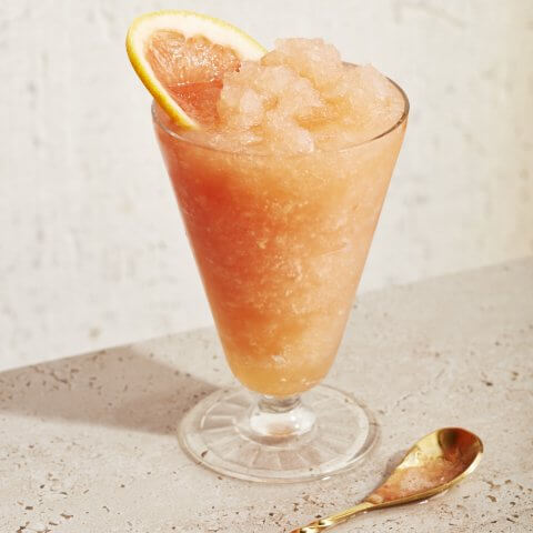 glass of peach slushie with grapefruit