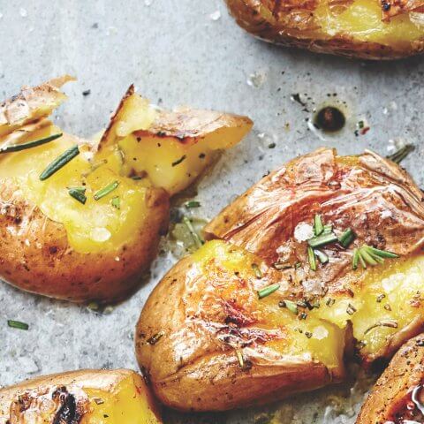 Smashed small potatoes sprinkled with rosemary.