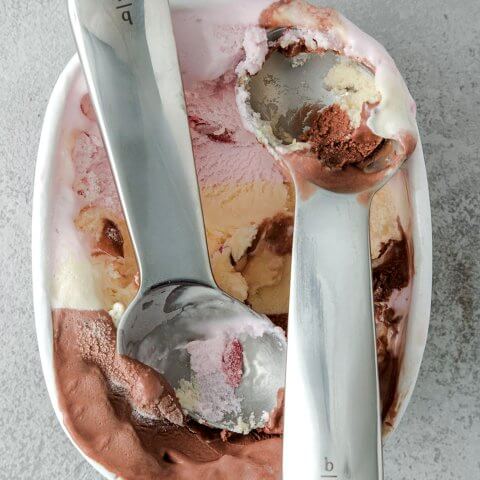 two ice cream scoops in container of ice cream