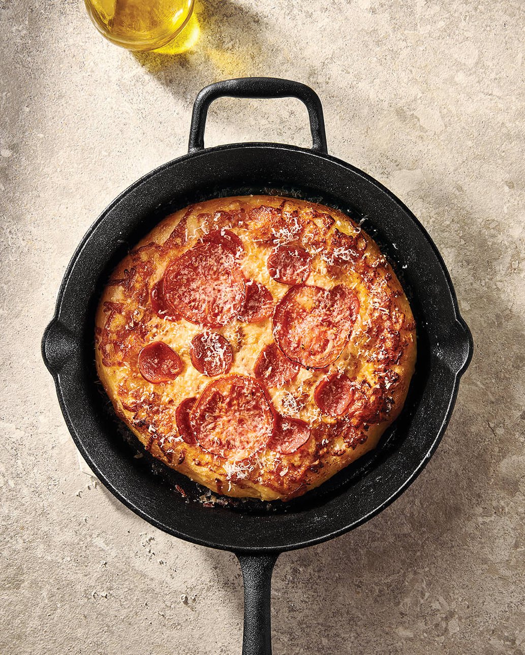 A black cast iron pan with a small pizza in it