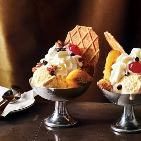 Silver bowls of ice cream with a wafer and sundae decorations