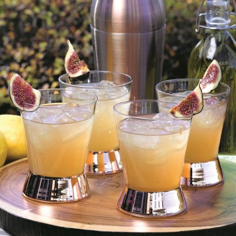 4 glasses with liquid and cocktail shaker outside on tray