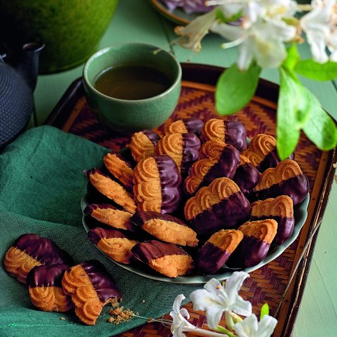 A plate of cookies with chocolate dip and green dishes