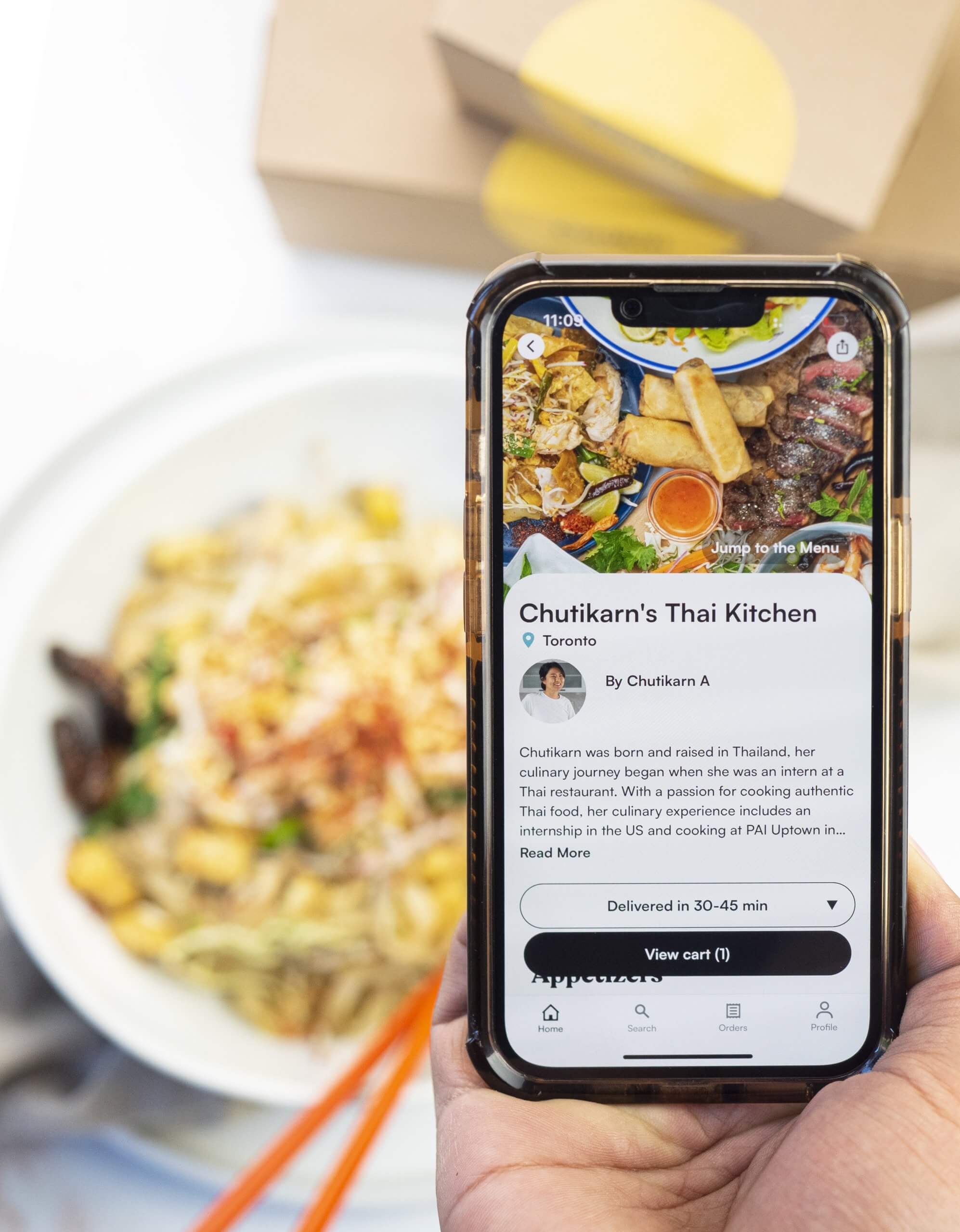 A phone with an order app held in front of food