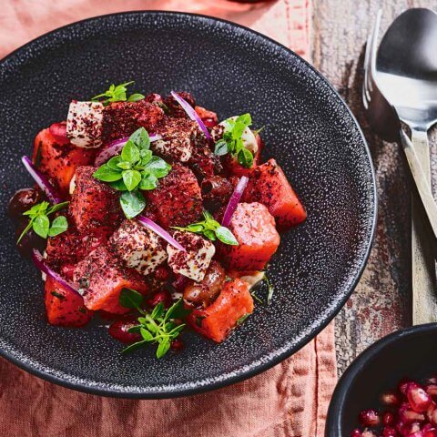 A black bowl of watermelon salad