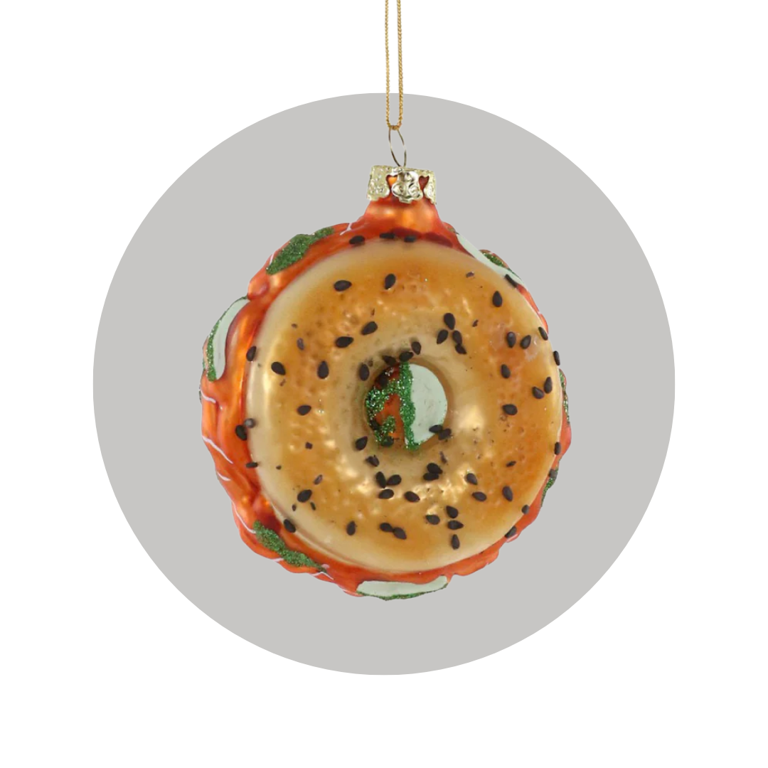 A bagel with lox ornament on a decorative gray circle background. 