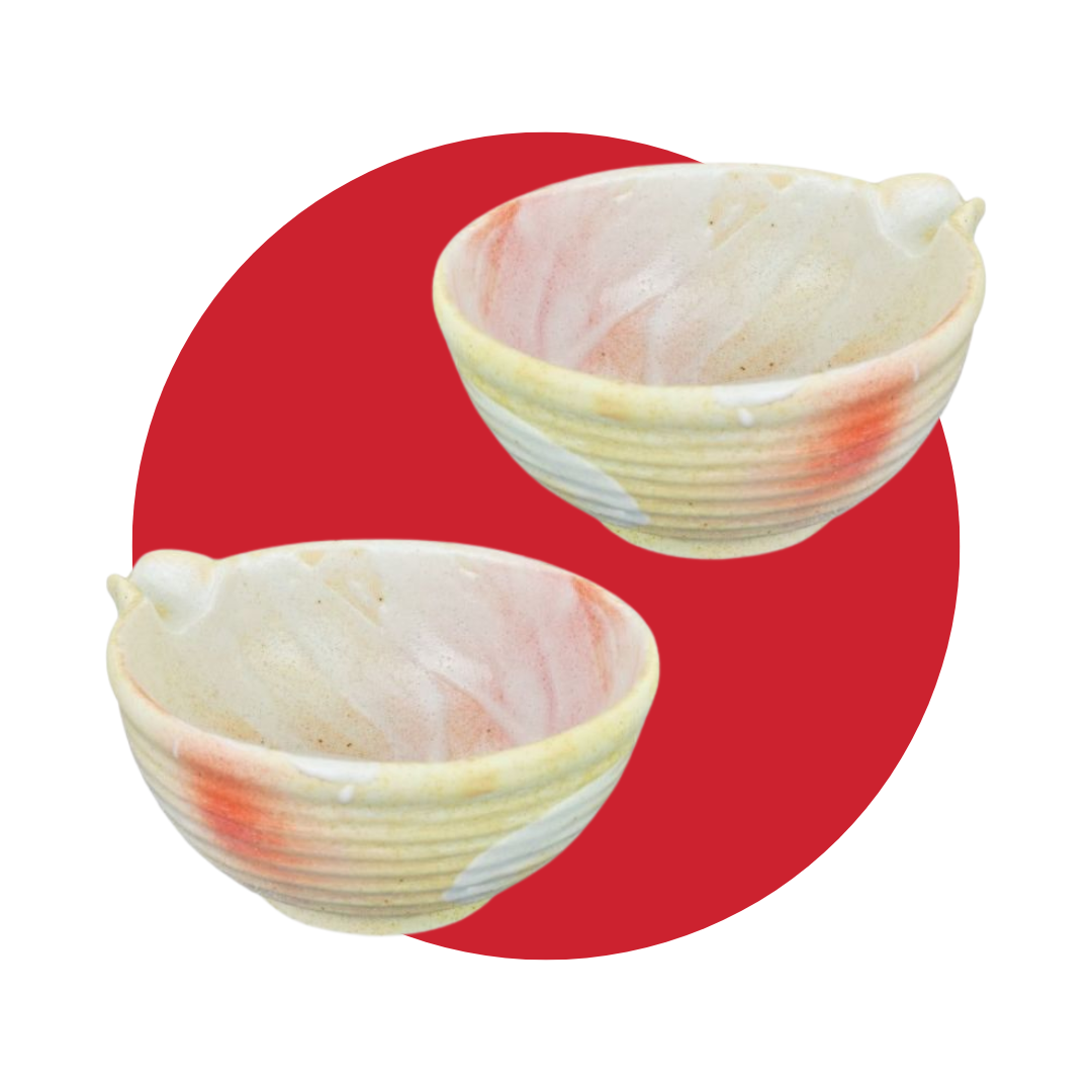 Two pink and yellow matcha bowls with a one-sided spout on a red circle background. 