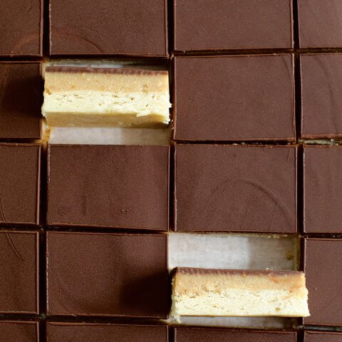 A pan of chocolate-covered bars with two on their sides.