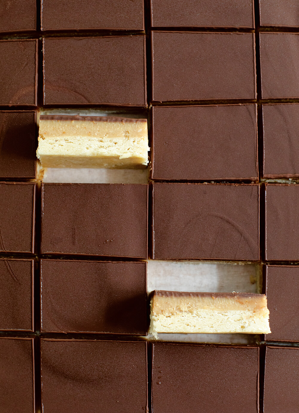 A pan of chocolate-covered bars with two on their sides.