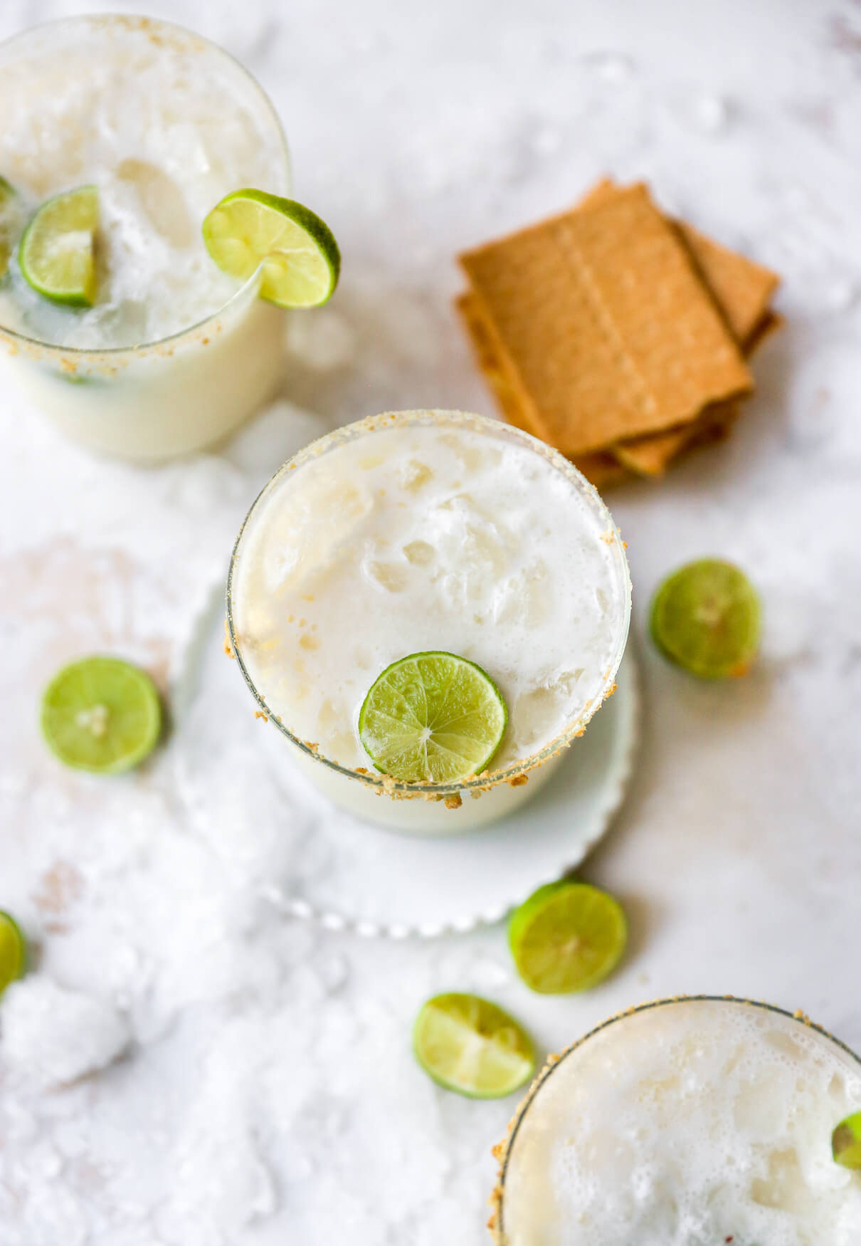 Margaritas garnished with line and graham cracker crumbs.