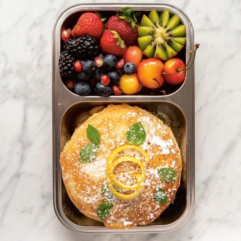 metal box with pancakes and fruit salad
