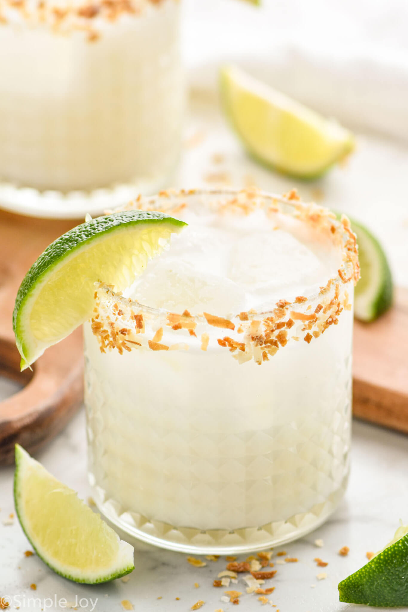 A margarita with lime wedge garnish and toasted coconut rim.