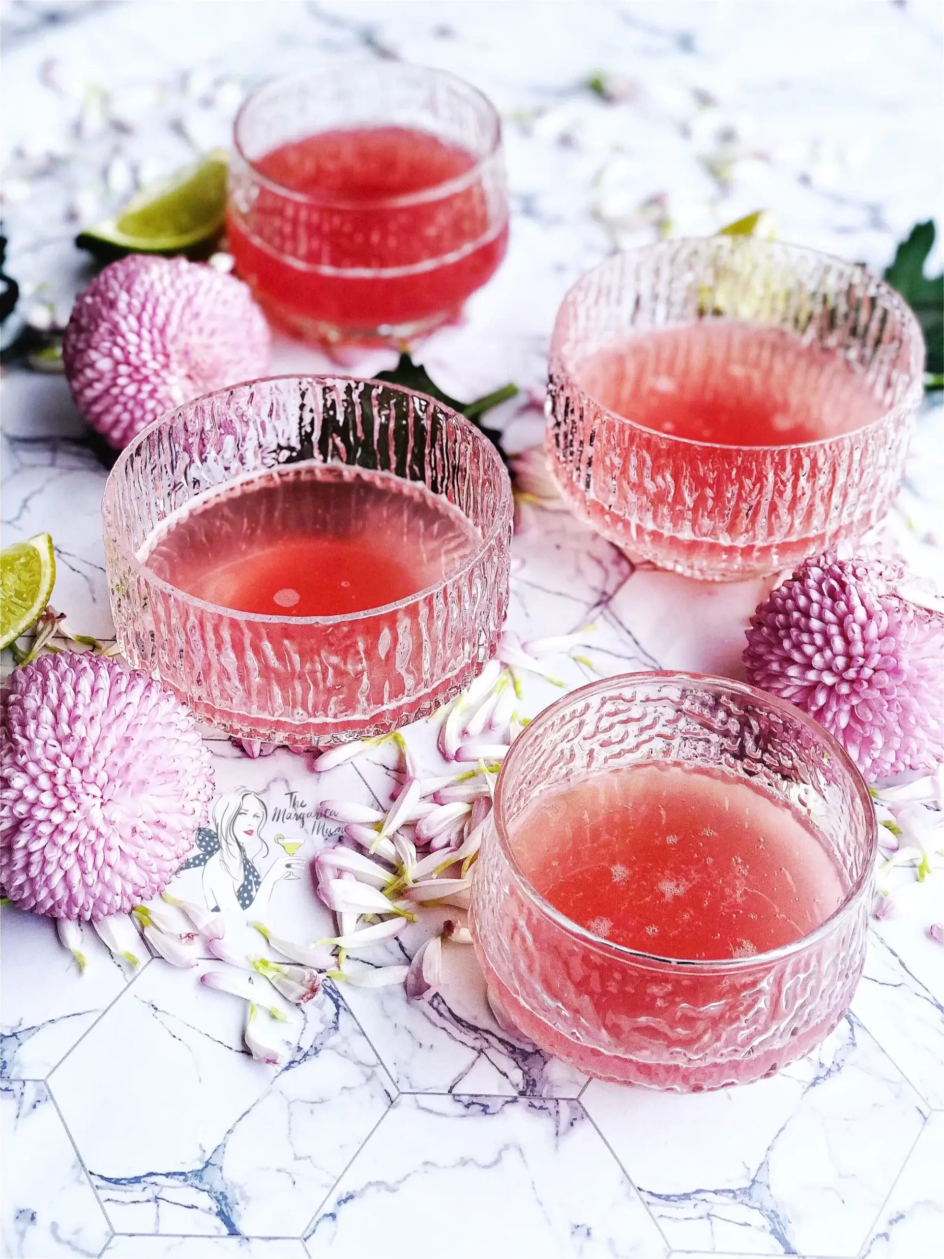 Glasses of a pink-red drink with flowers.