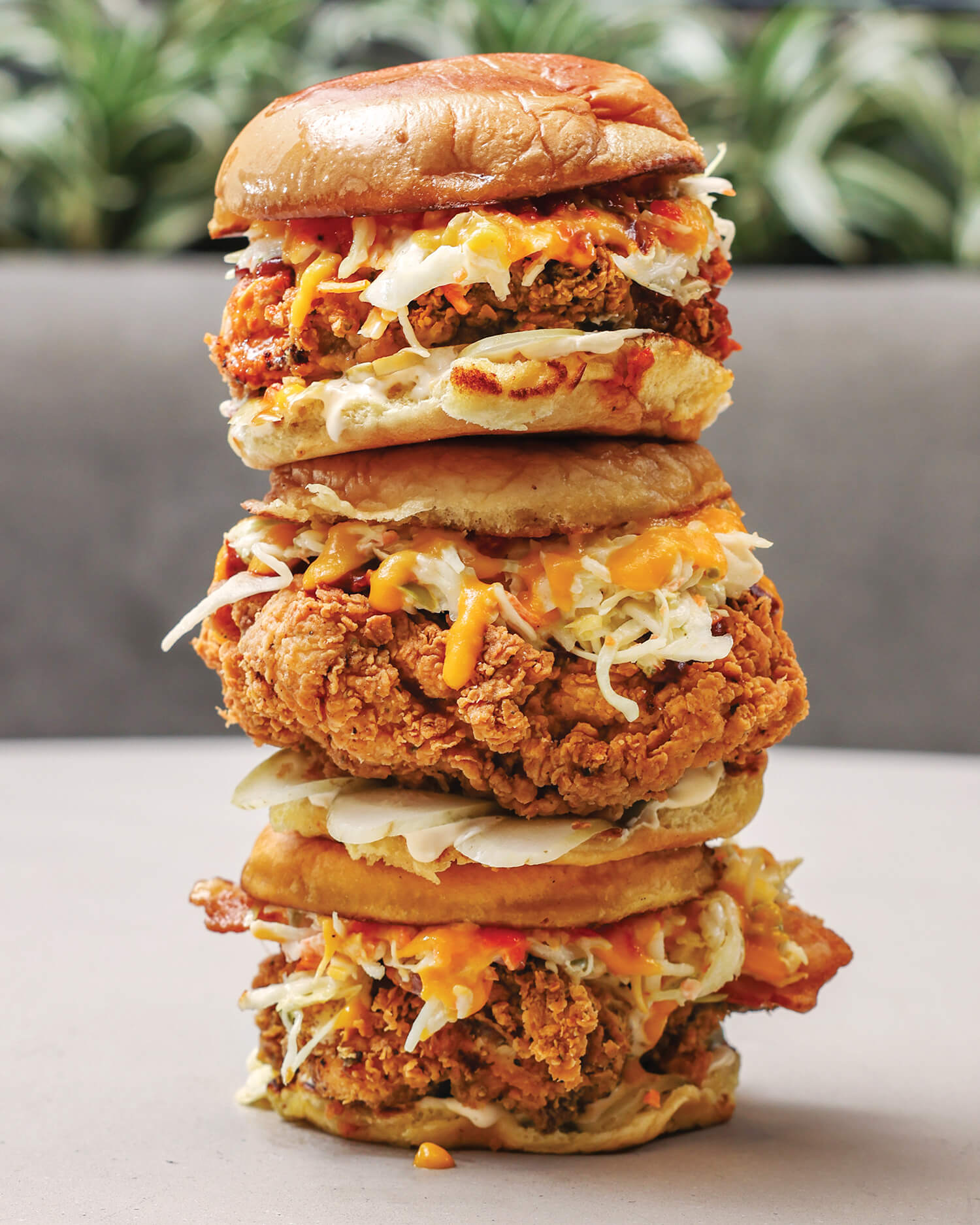 Three fried chicken sandwiches stacked on top of one another
