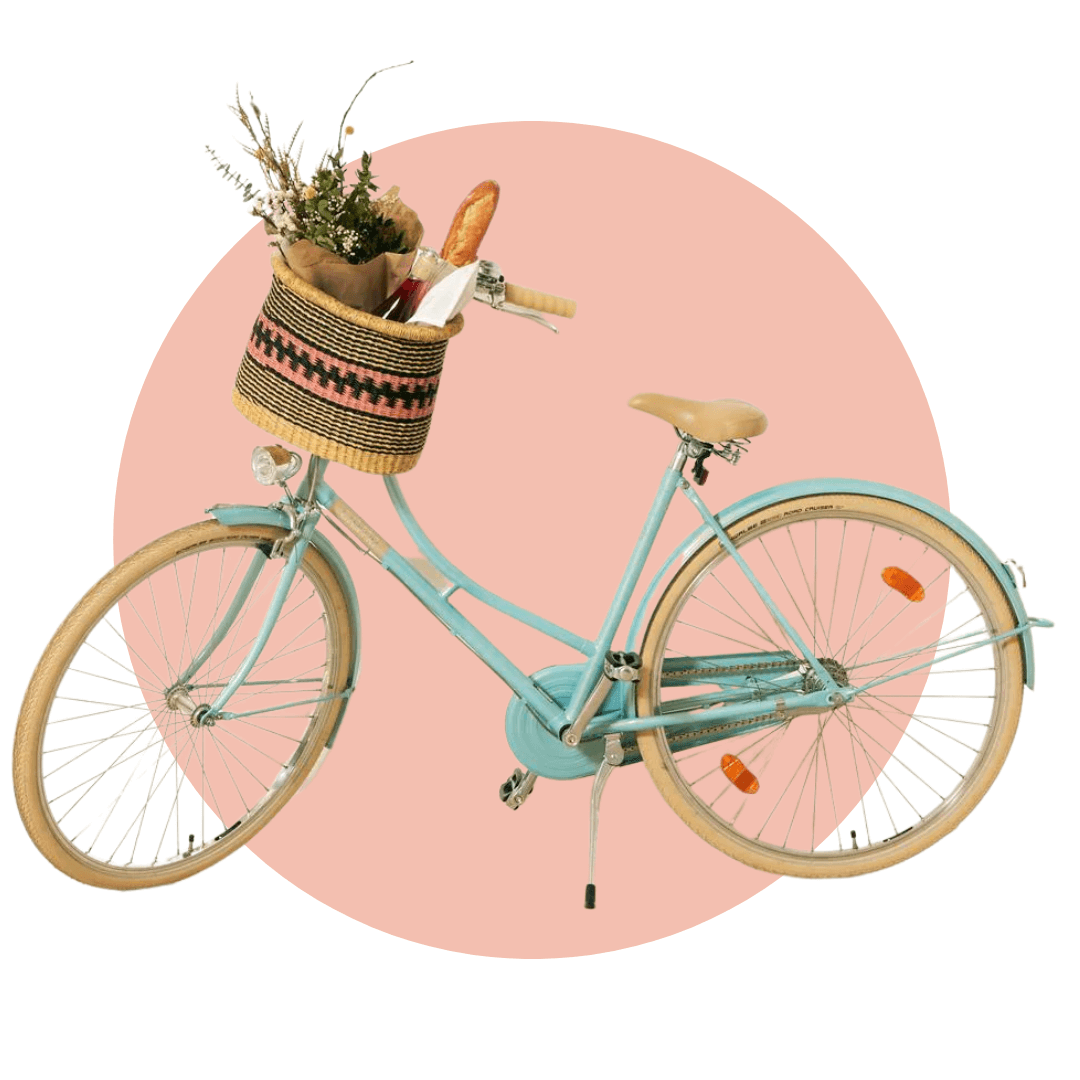 A blue bicycle with a shopping basket on a light pink circle graphic