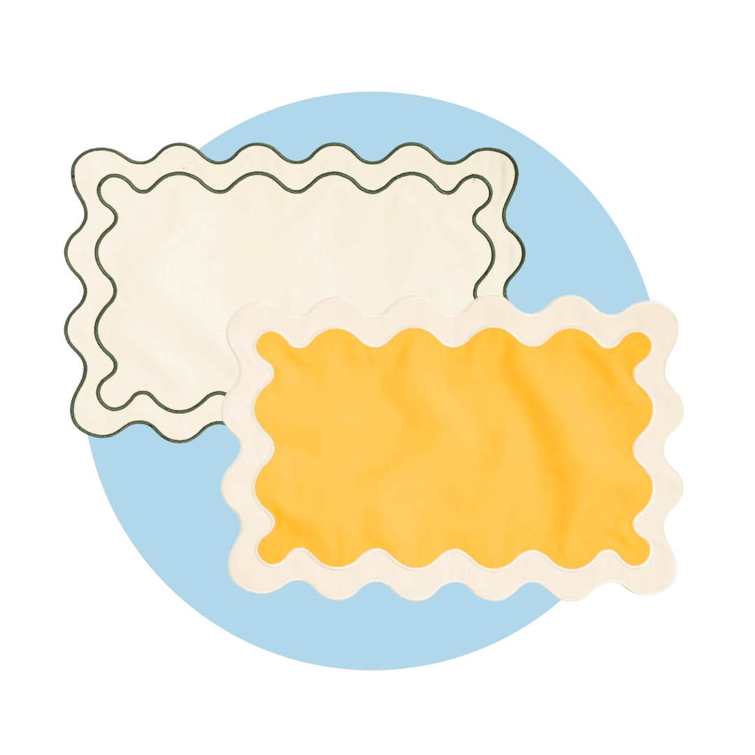 A yellow and white placemat and a green and white placemat with wavy edges on a light blue circle graphic
