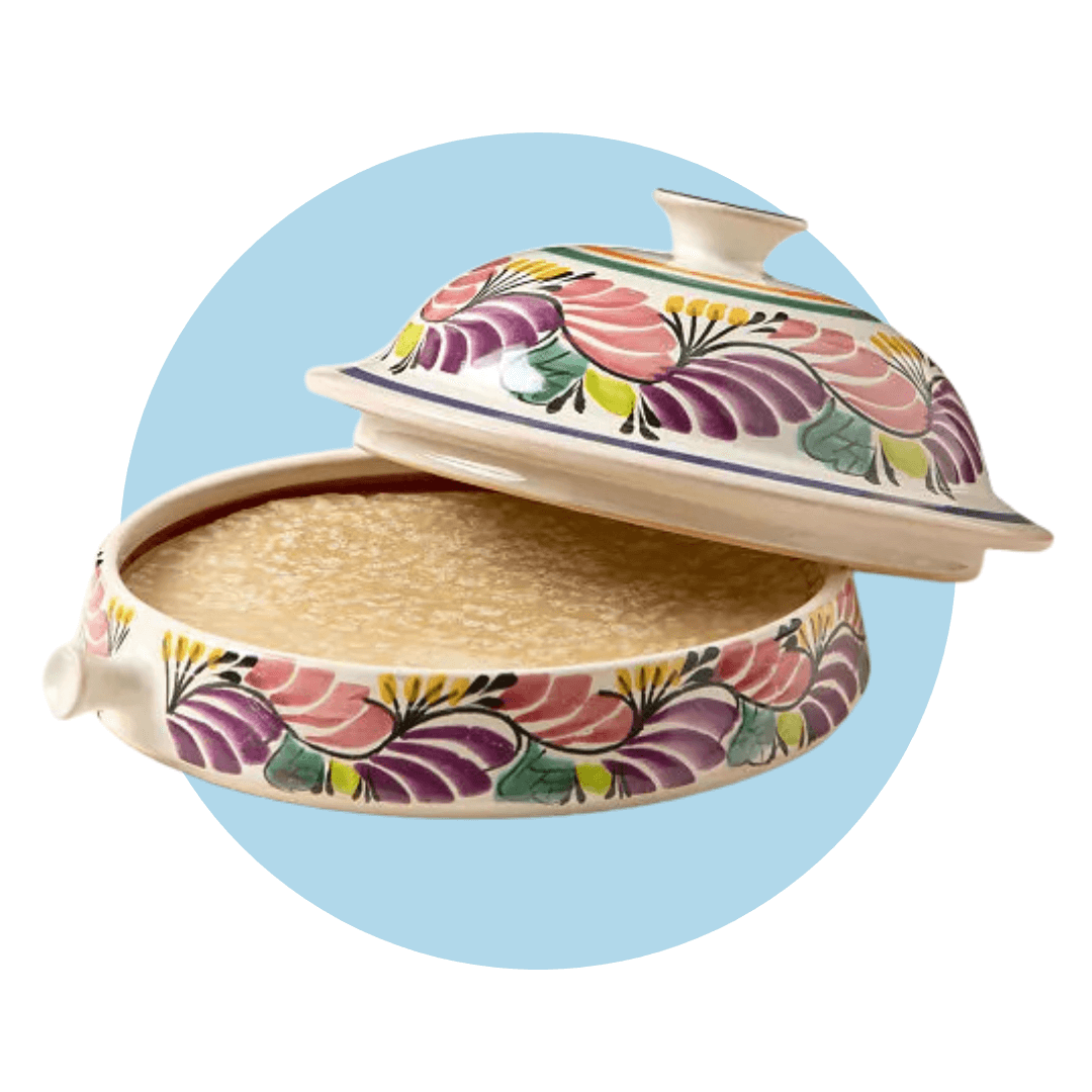 A painted ceramic tortilla warmer with the lid ajar