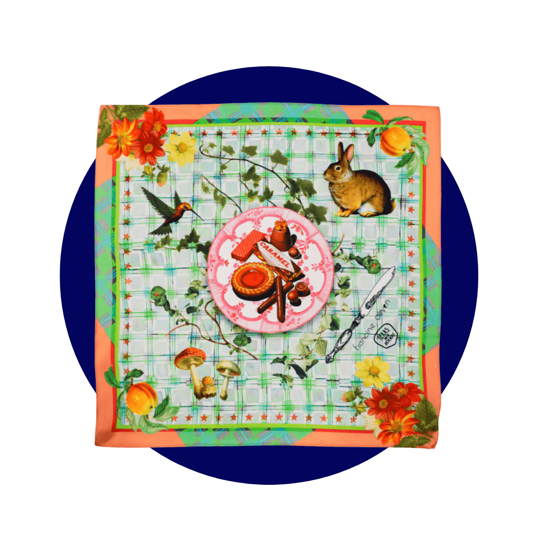 A green and orange silk square depicting animals having a picnic on a dark blue circle graphic
