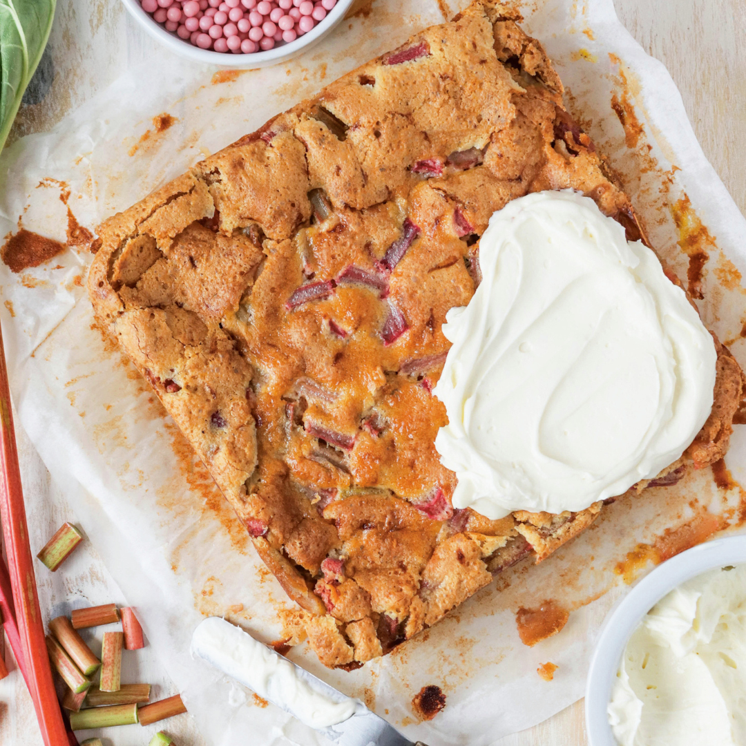 Recipe for rhubarb custard bars topped with a dollop of homemade cream cheese icing.