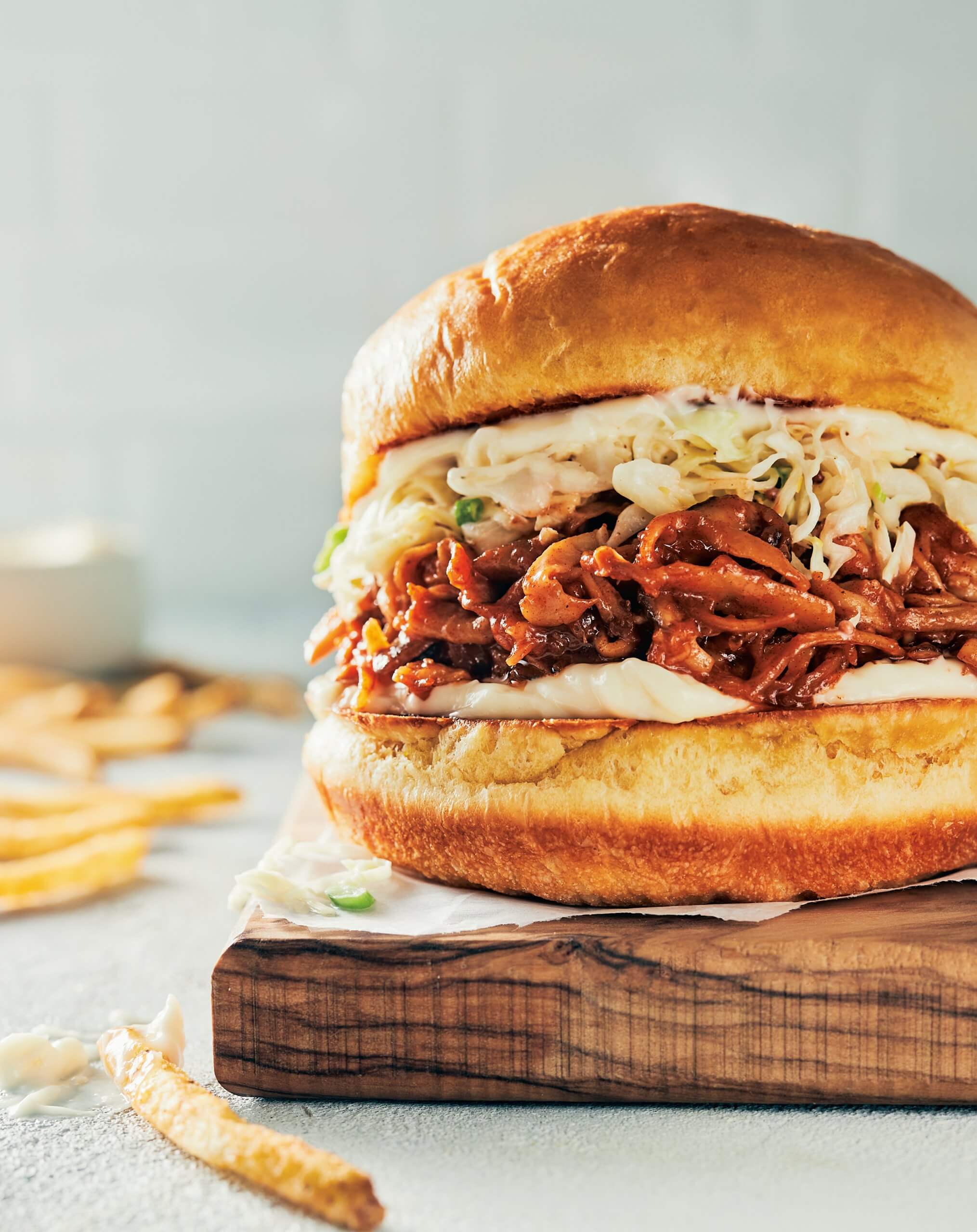 A hamburger bun with coleslaw and mushrooms prepared in the style of pulled pork.