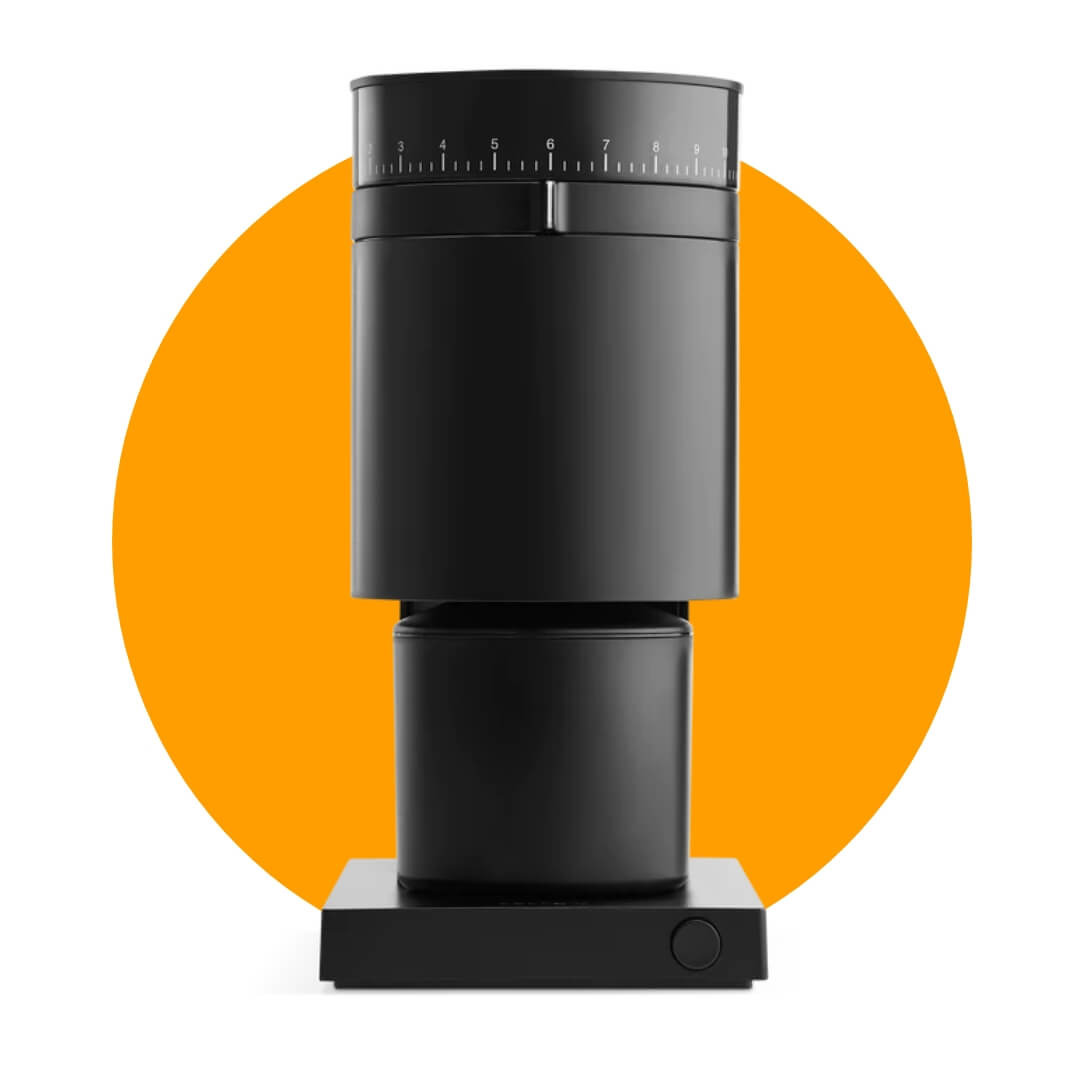 A minimalistic black coffee grinder on an orange circle graphic.