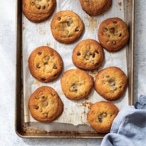 A silver baking sheet with chocolate chip cookies