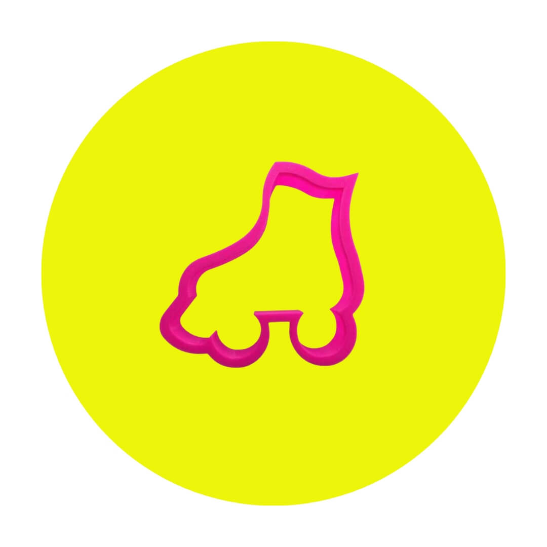 A hot pink cookie cutter shaped like an old-fashioned roller skate on a neon yellow circle graphic