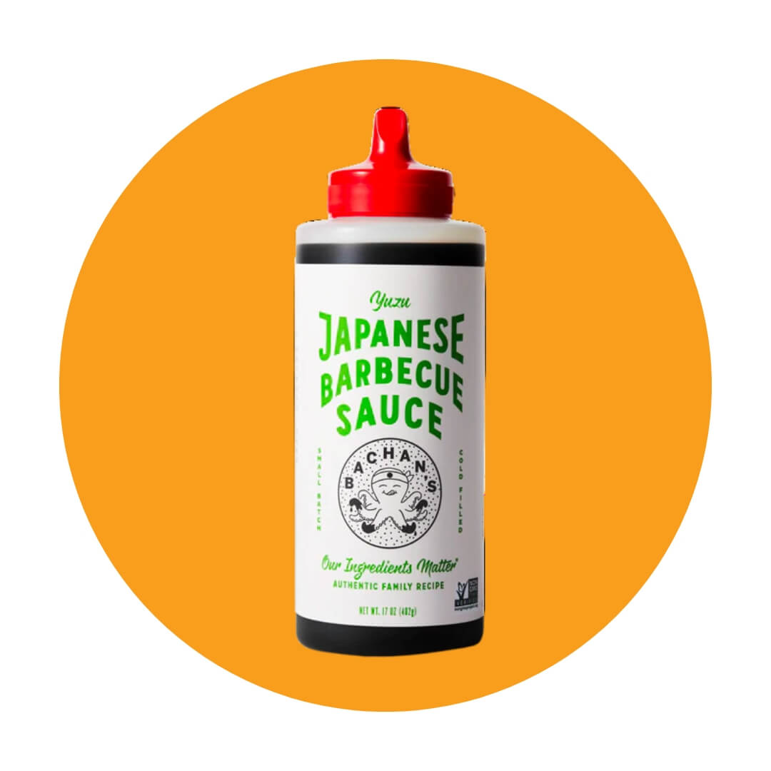 A white squeeze bottle with a red cap and green lettering over an orange circle graphic