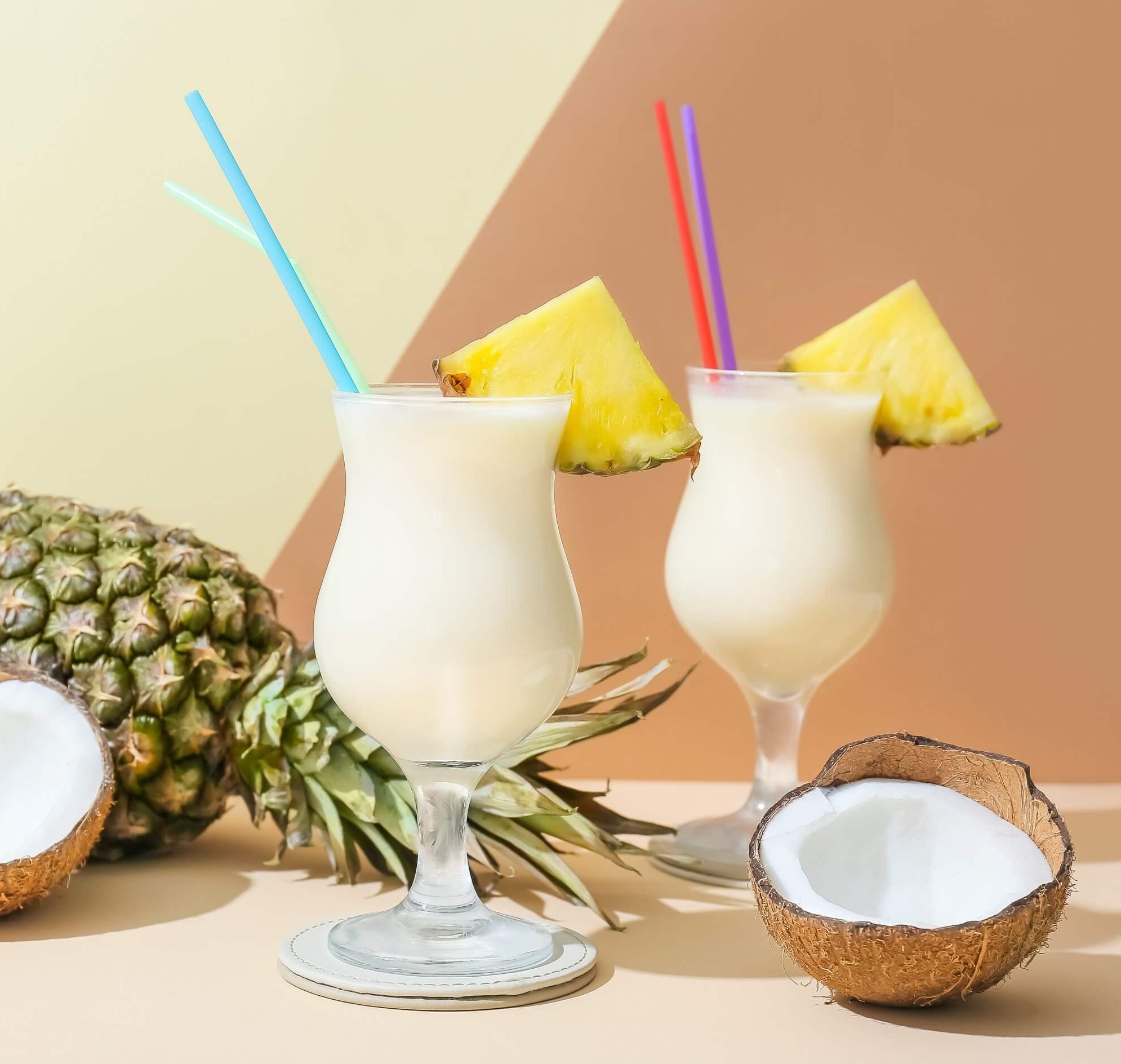 Glasses with Pina Colada cocktail on light background