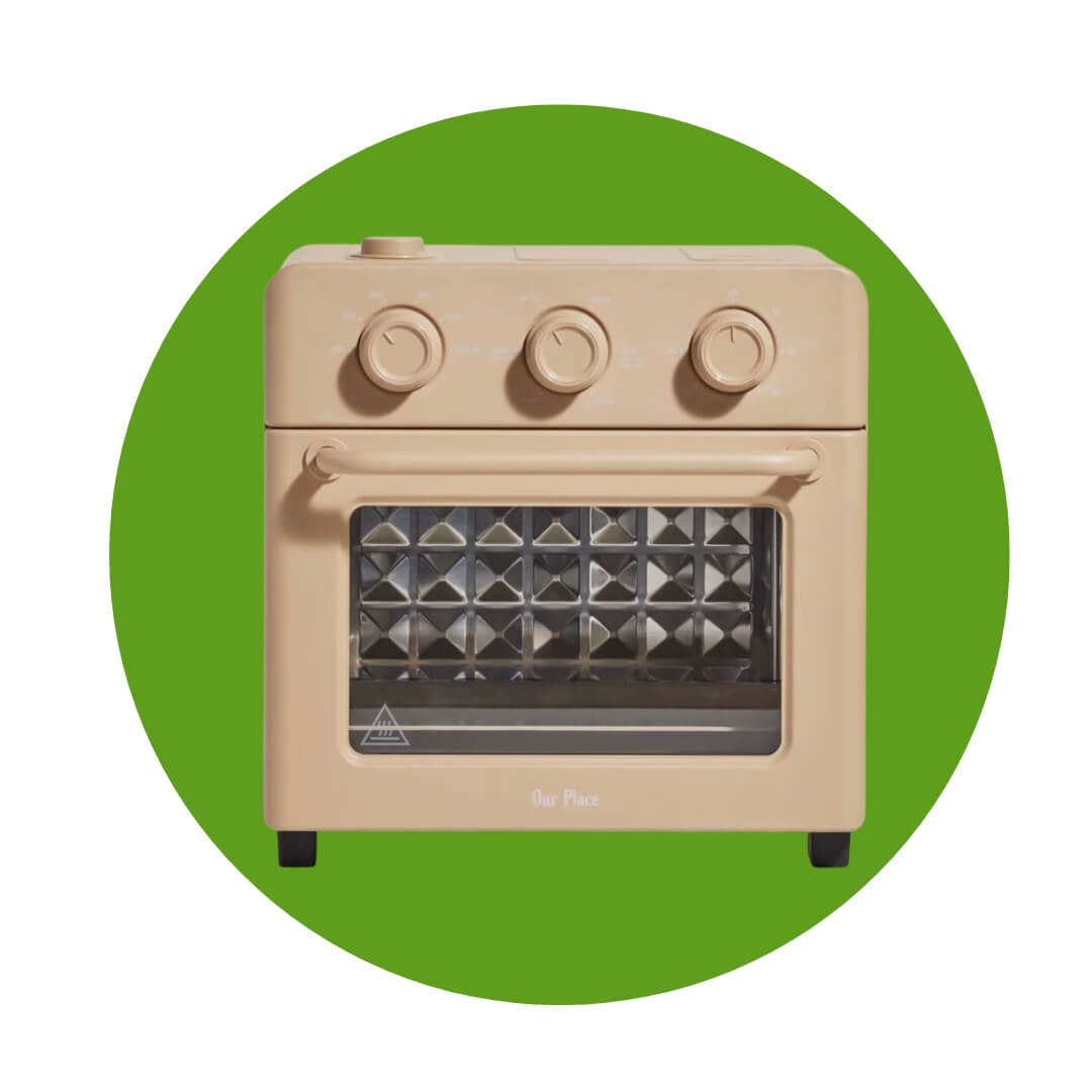 A sand-coloured tabletop oven over a green circle graphic
