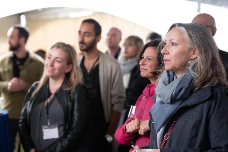 A group of people standing together, as if listening to someone speak