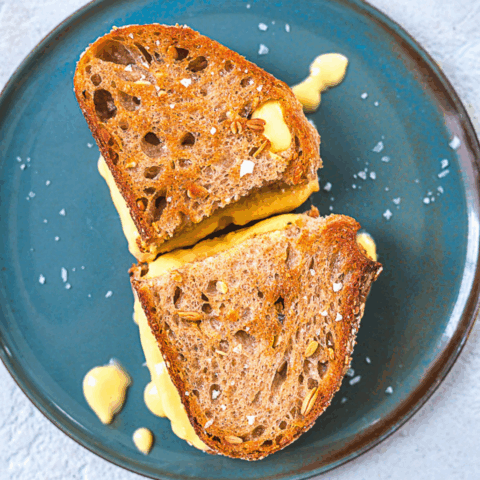 Hannah Sunderani Vegan Grilled Cheese Sandwich on a blue plate with melting cheese