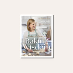A book cover of Anna Olson's Baking Wisdom in a light frame