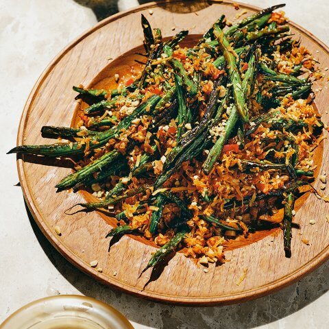A plate of green beans crusted with coconut flakes