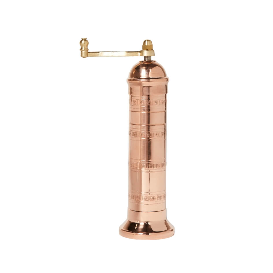 A copper pepper mill with a gold lever