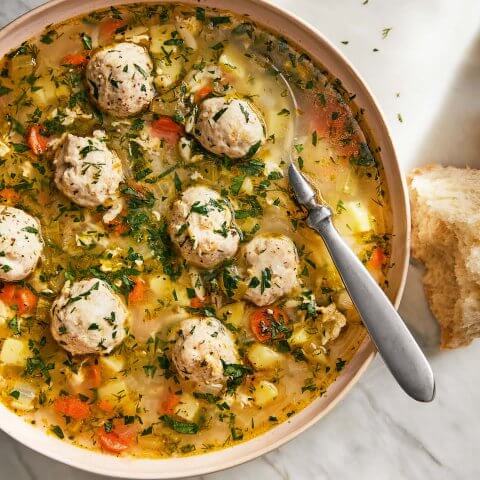 A bowl of soup with turkey meatballs