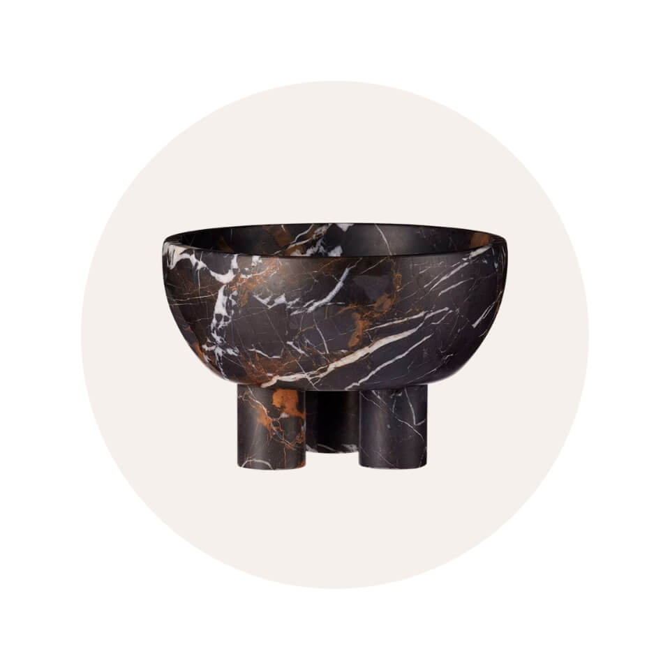 A dark marble footed bowl in a cream-coloured circle