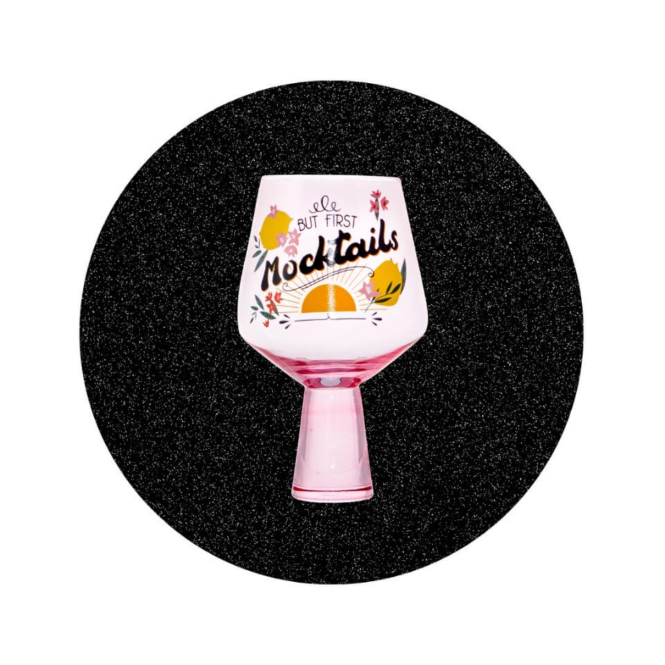 A pink cocktail glass with tropical illustrations in a sparkly black circle