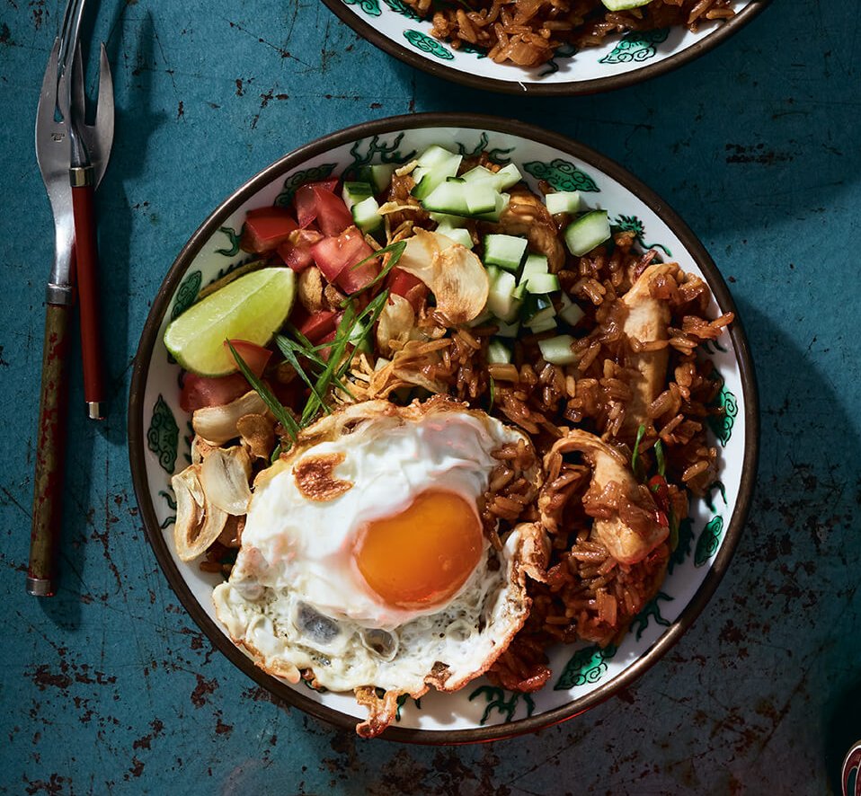 Bowls of Indonesian nasi goreng on a blue surface