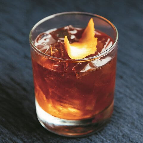 A negroni cocktail on a dark wooden surface