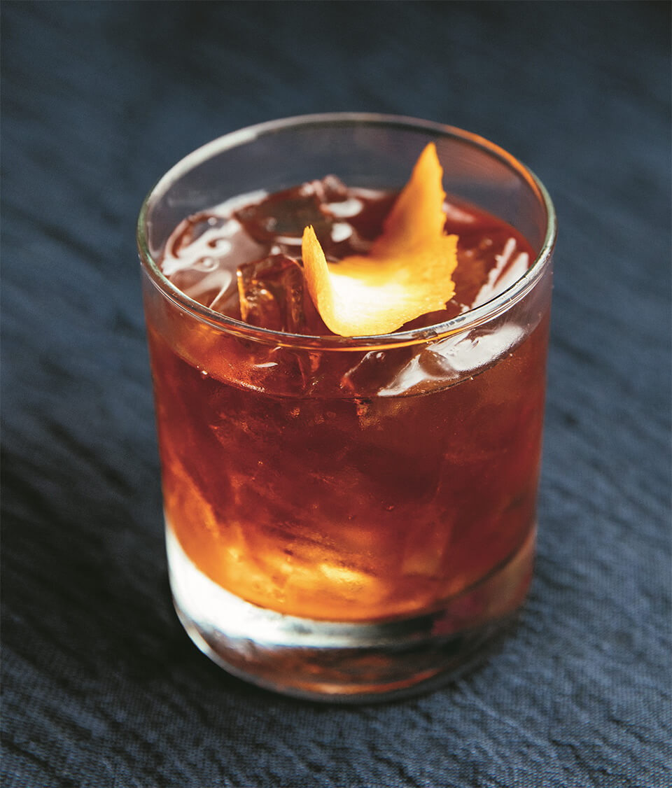 A negroni cocktail on a dark wooden surface