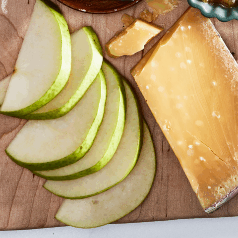 Sliced Anjou Pears and hard cheese on a cutting board