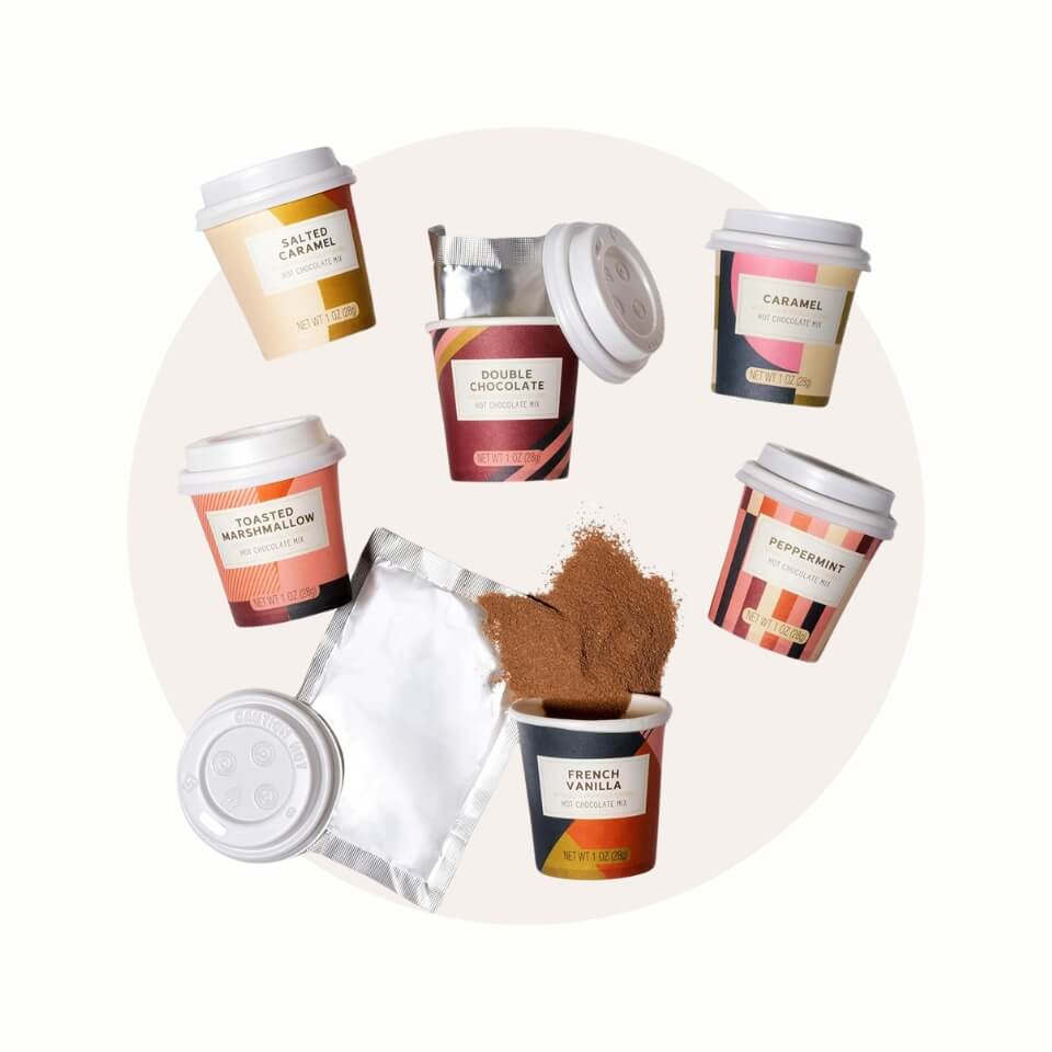 Six miniature takeaway cups with hot chocolate mix