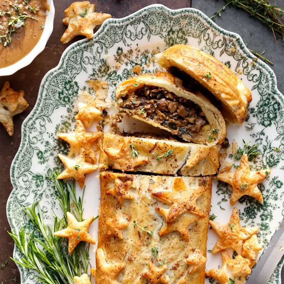 A green floral plate with a sliced wellington and miniature star cutouts