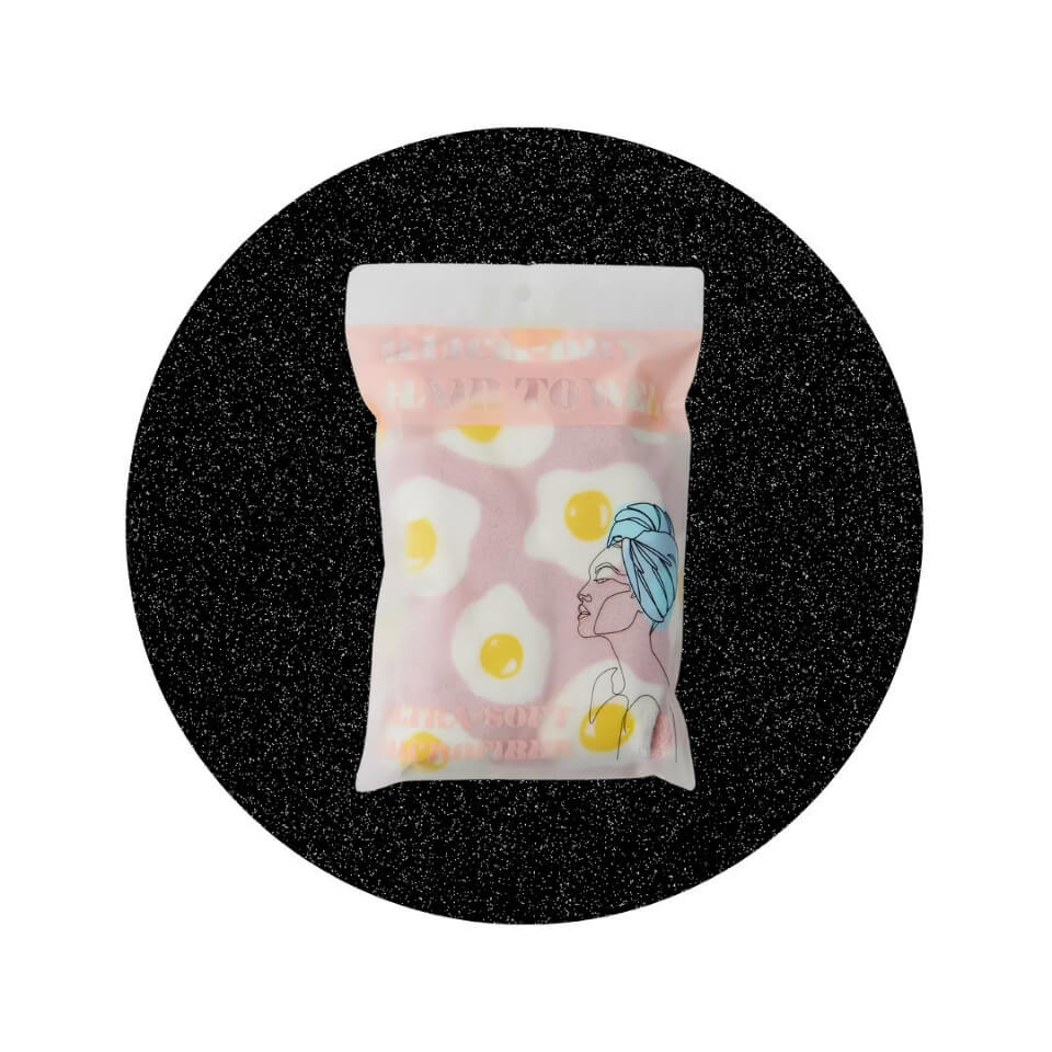 A pink towel decorated with fried eggs in a sparkly black circle