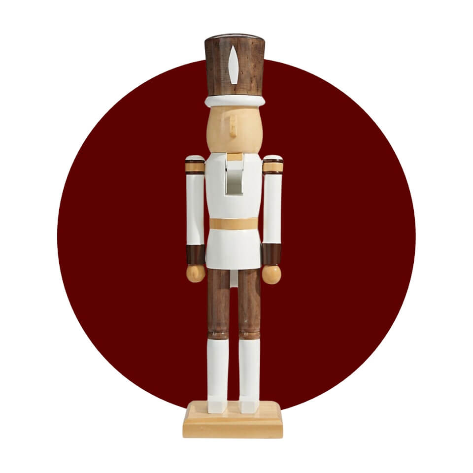 A nutcracker in white and wooden tones over a maroon circle