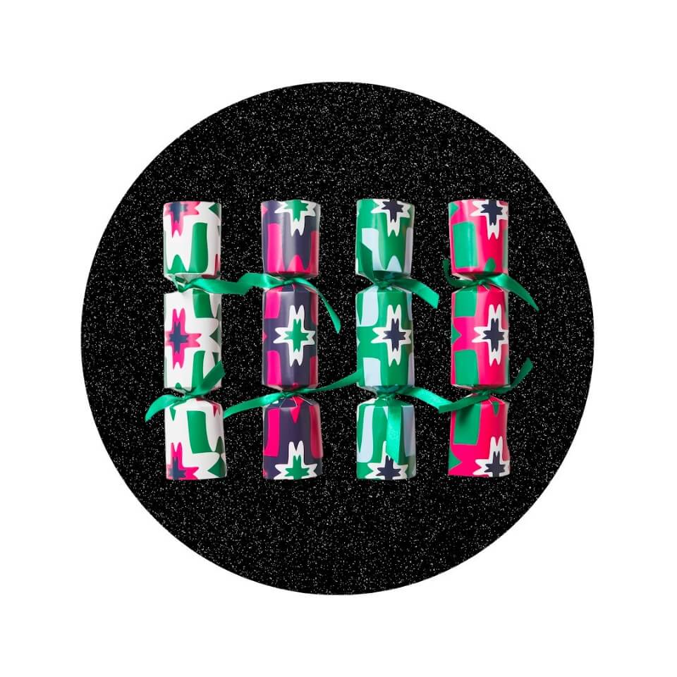 Four Christmas crackers with geometric designs in shades of green, pink and purple in a sparkly black circle