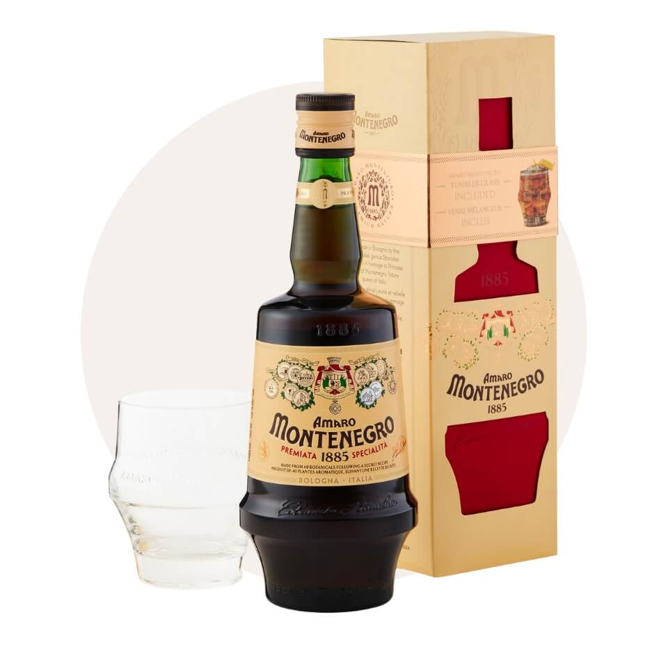 A bottle of Amaro Montenegro with a wooden box and short glass over a cream-coloured circle