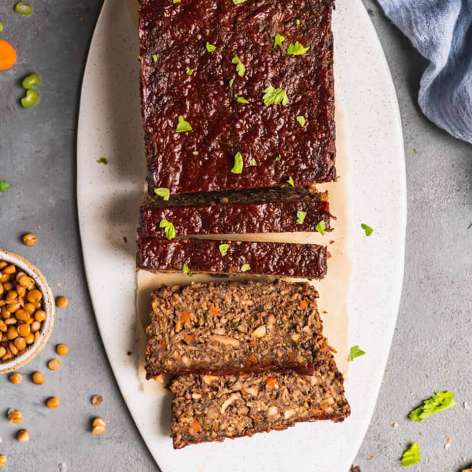 A sliced lentil loaf on a white platter
