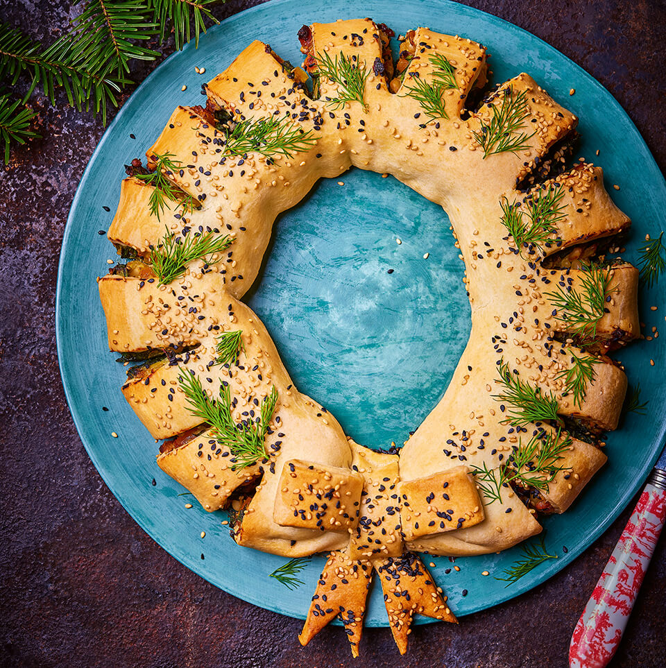 A puff pastry wreath on a blue plate